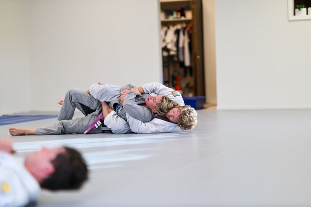 Two members working a back control exchange during class at Golden Jiu Jitsu