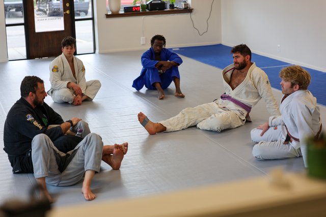 Class seated in a circle during instruction at Golden Jiu Jitsu