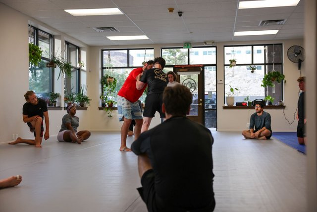 Class seated in a circle watching a standup demonstration at Golden Jiu Jitsu